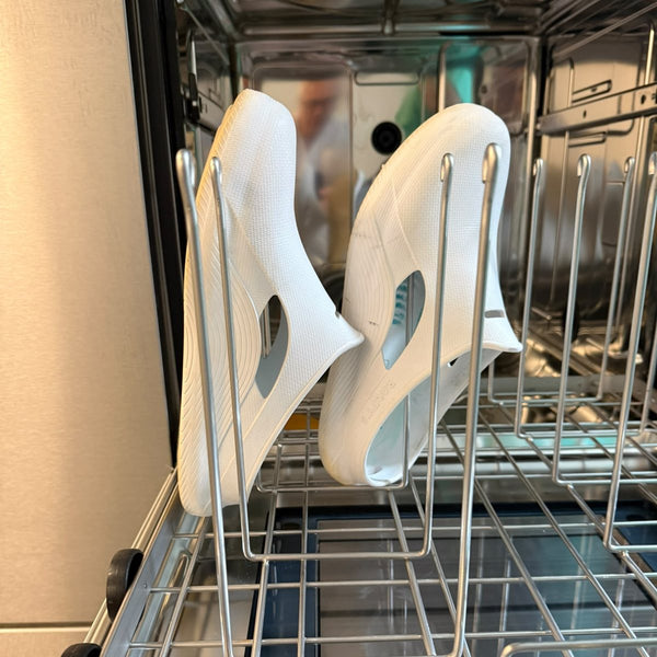 Zwei weiße RALFY'S Außenschalen im Korb einer OP-Schuhwaschmaschine